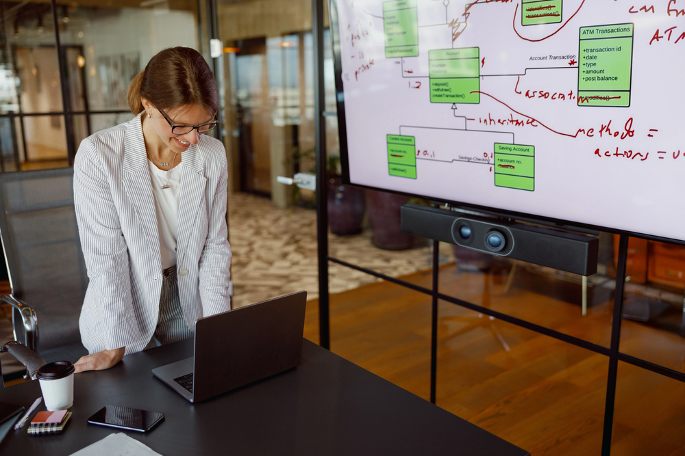 Woman presenting technology web chart and data to team